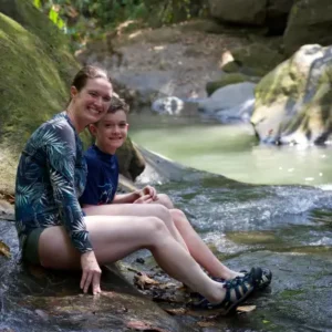 Mother and child enjoying a serene waterfall during a family adventure in Costa Rica with kids.