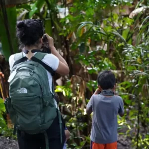 Mother and son exploring Manuel Antonio National Park with binoculars.